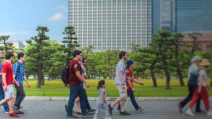 澳门金沙线上赌博官网 students walk together down a street.