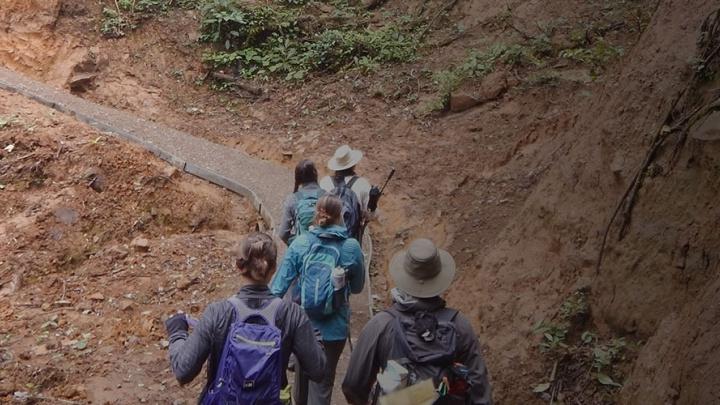 Students 和 faculty hiking across a terrain on a study abroad trip