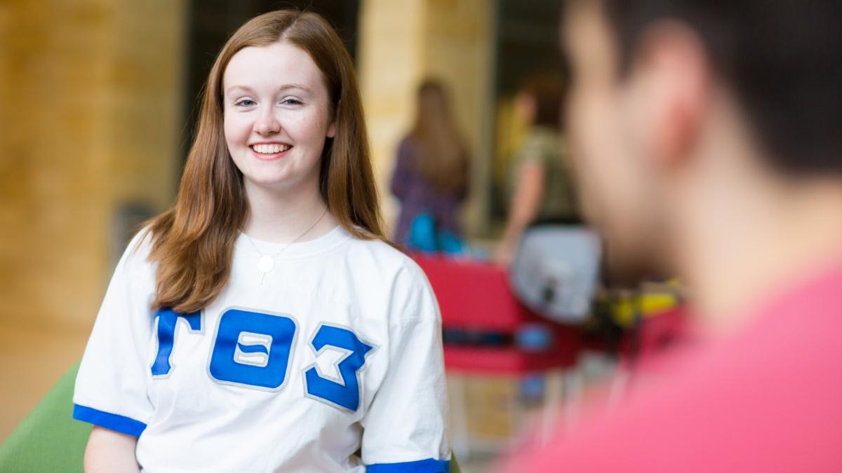 a woman in a Sigma Theta Tau jersey smiles